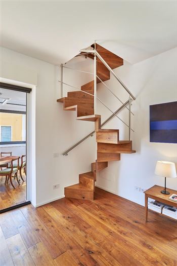Wendeltreppe mit Edelstahlgeländer und Bibliothek