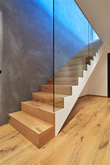 Stufen in Holz hinter Ganzglas
